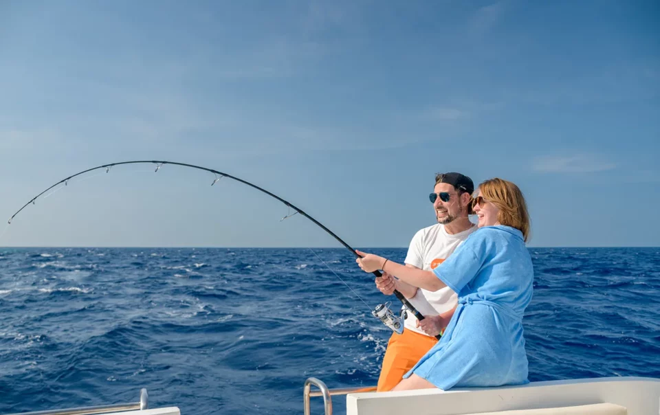 young couple fishing together on the boat