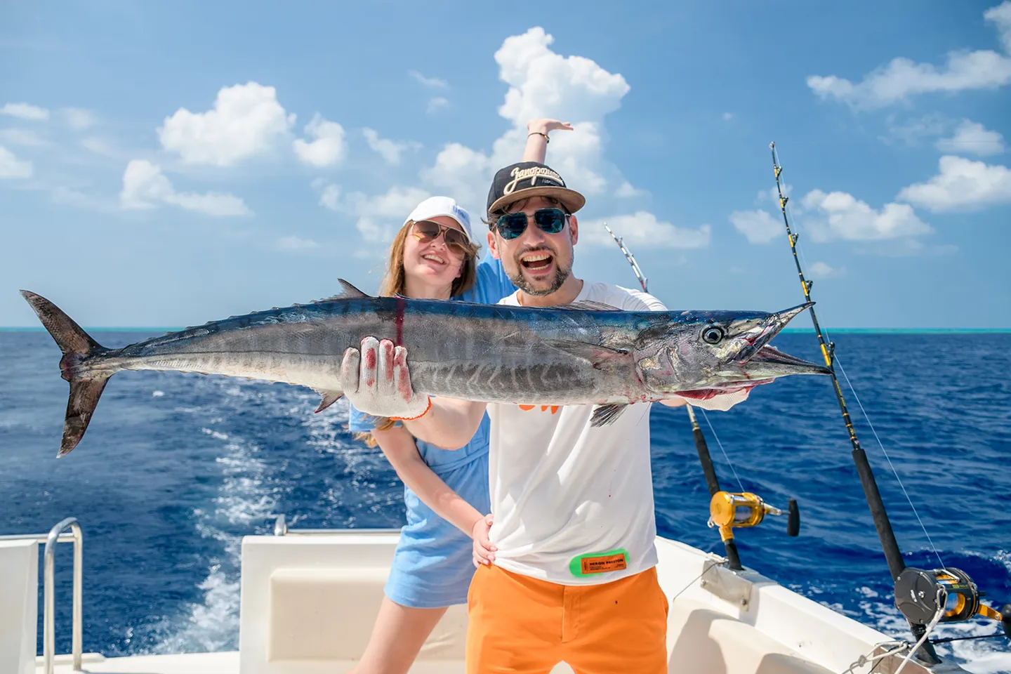 Happy couple with a big catch on a fishing trip in the Maldives
