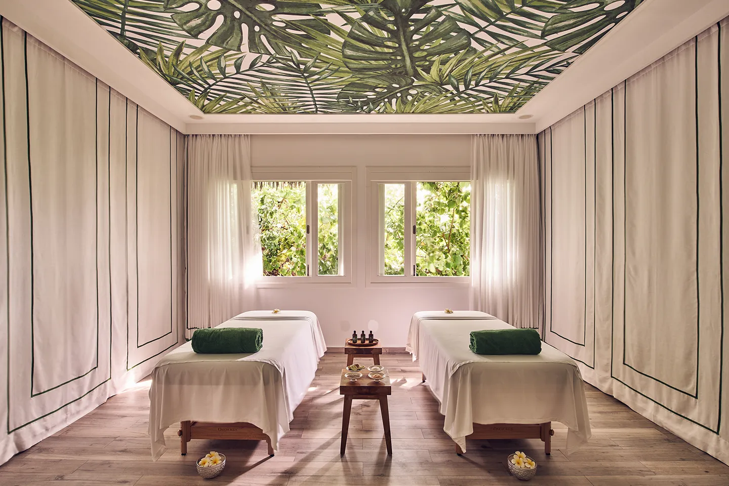 treatment room in the fehi spa with two loungers and ceiling decorated with palm trees