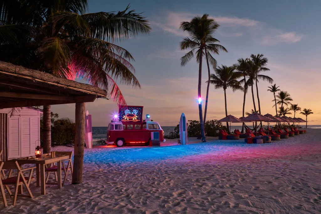 Illuminated VW party bus at Crab Shack beach at night